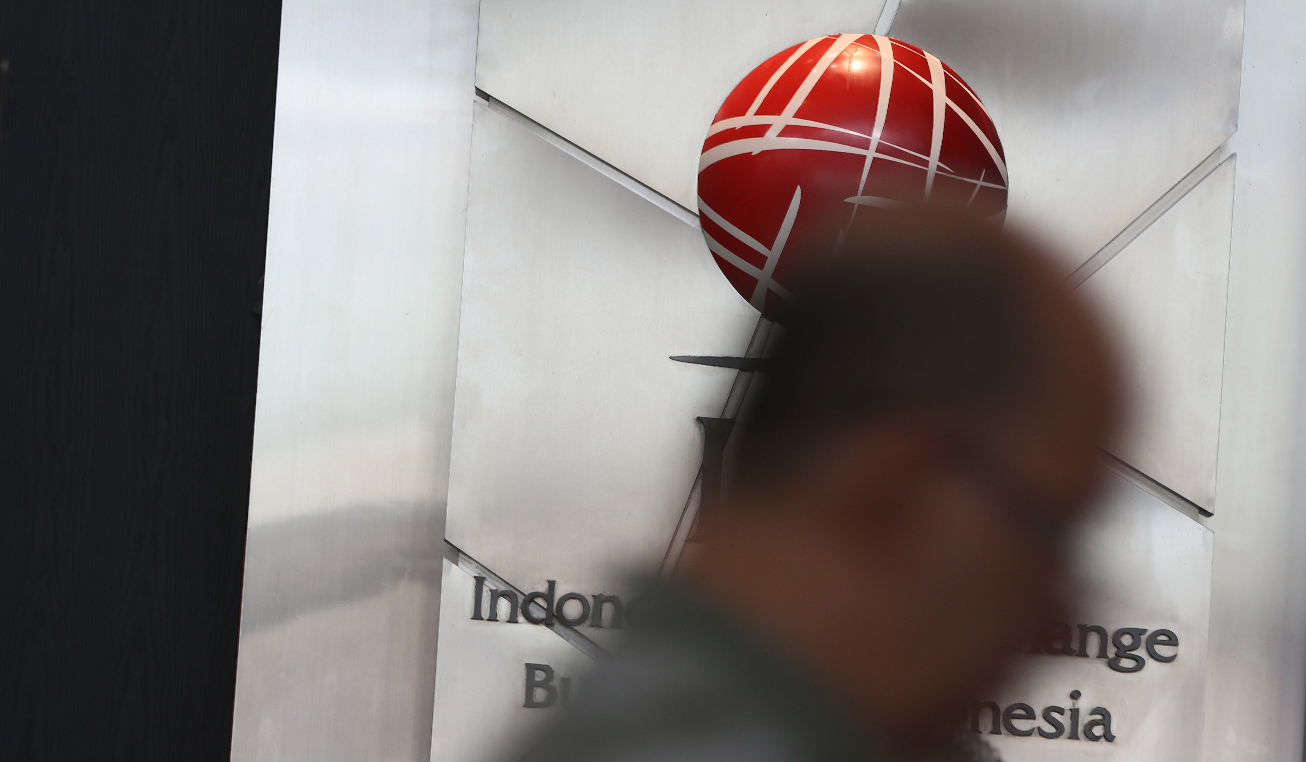 Dua pengunjung melintas didepan papan IHSG di BEI, Jakarta. (Agus Priatna/SinPo.id)