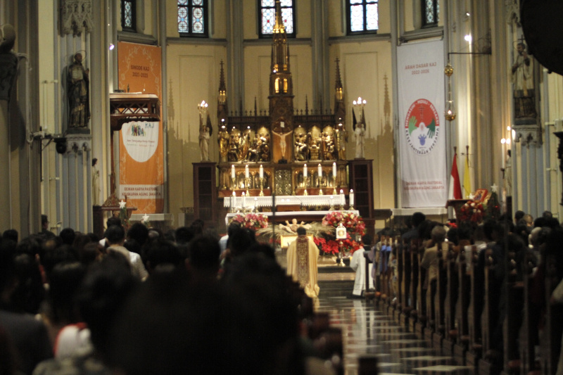 Jemaat Kristiani melaksanakan ibadah malam Misa Natal di Gereja Katedral (Ashar/SinPo.id)