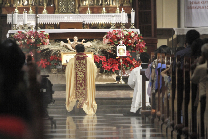 Jemaat Kristiani melaksanakan ibadah malam Misa Natal di Gereja Katedral (Ashar/SinPo.id)