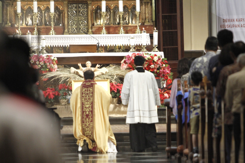 Jemaat Kristiani melaksanakan ibadah malam Misa Natal di Gereja Katedral (Ashar/SinPo.id)