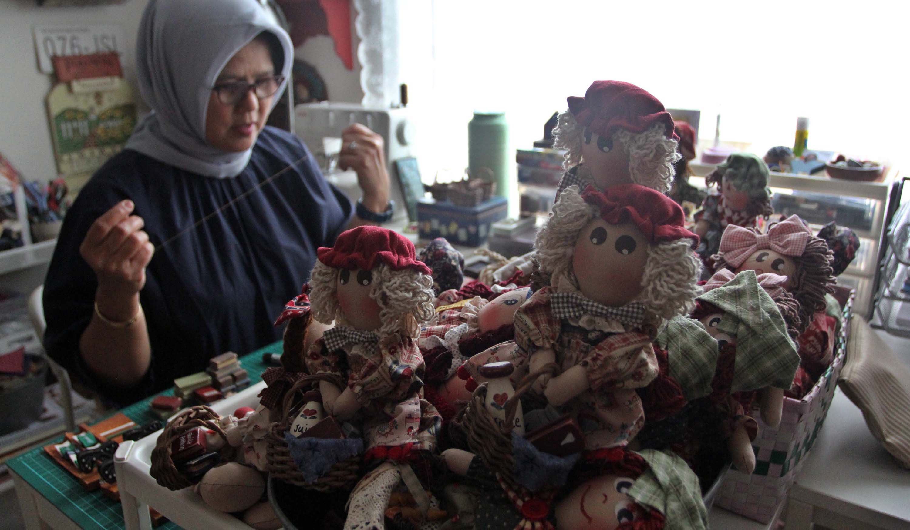 Pembuatan boneka dari kain perca. (Agus Priatna/SinPo.id)