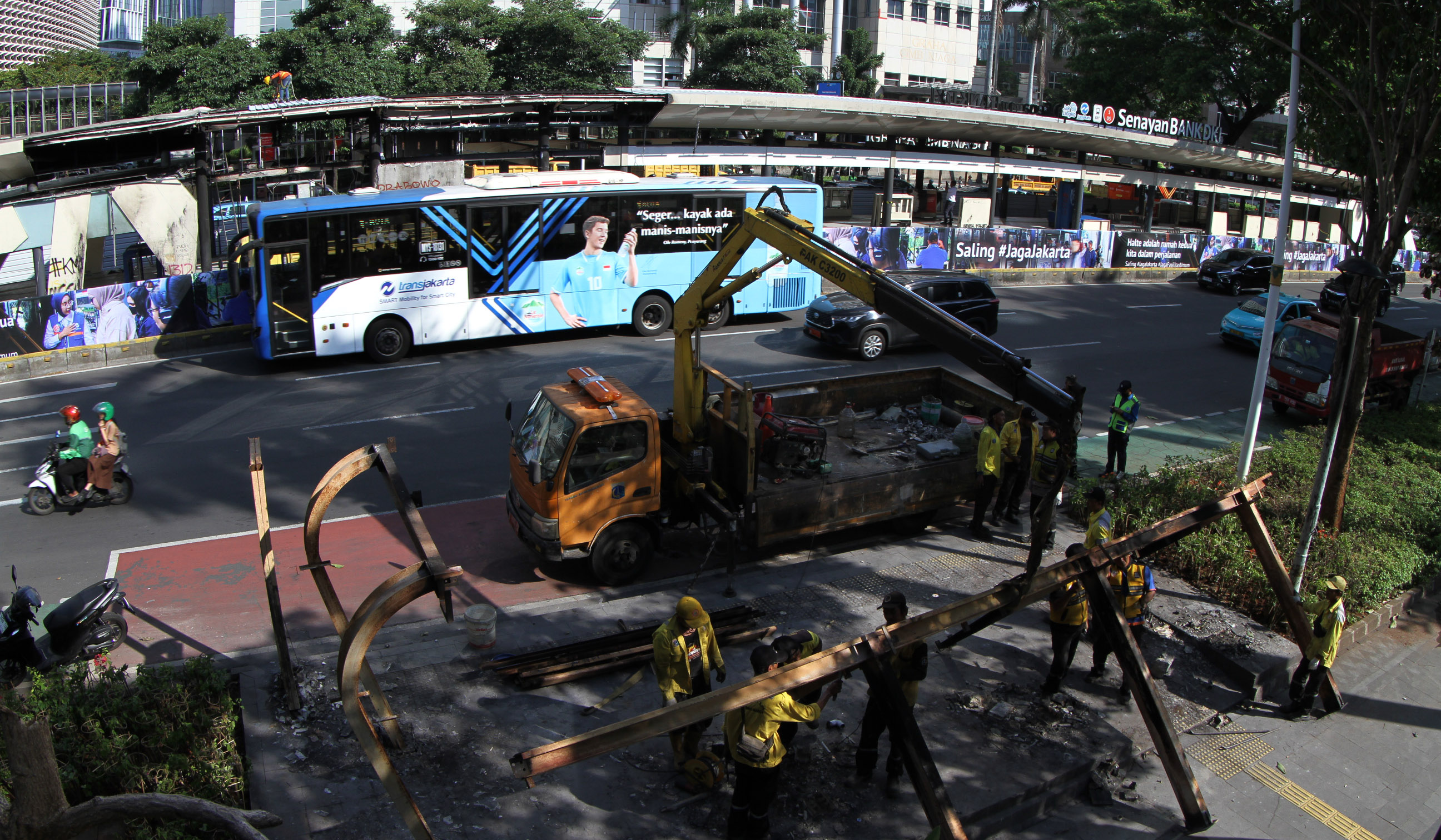 Petugas membersihakan halte yang rusak pascademo di Jakarta. (Agus Priatna/SinPo.id)