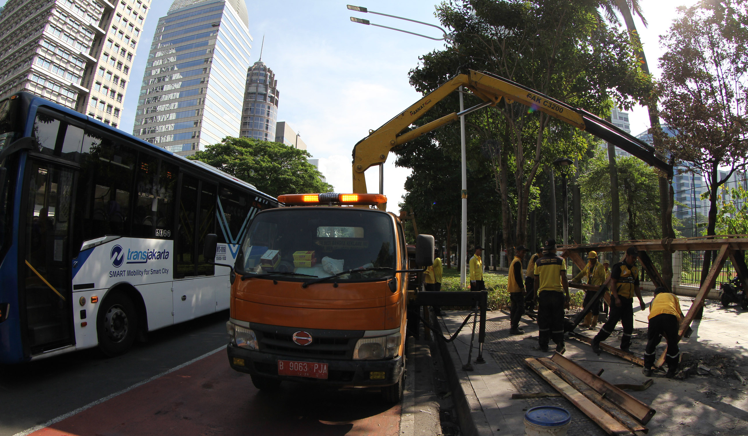 Petugas membersihakan halte yang rusak pascademo di Jakarta. (Agus Priatna/SinPo.id)