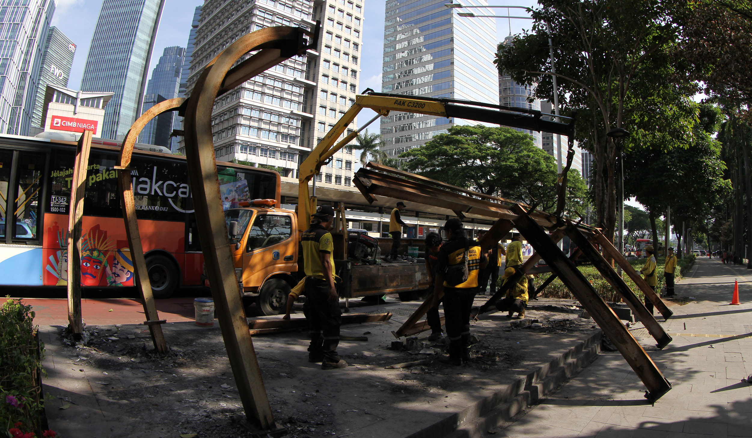 Petugas membersihakan halte yang rusak pascademo di Jakarta. (Agus Priatna/SinPo.id)