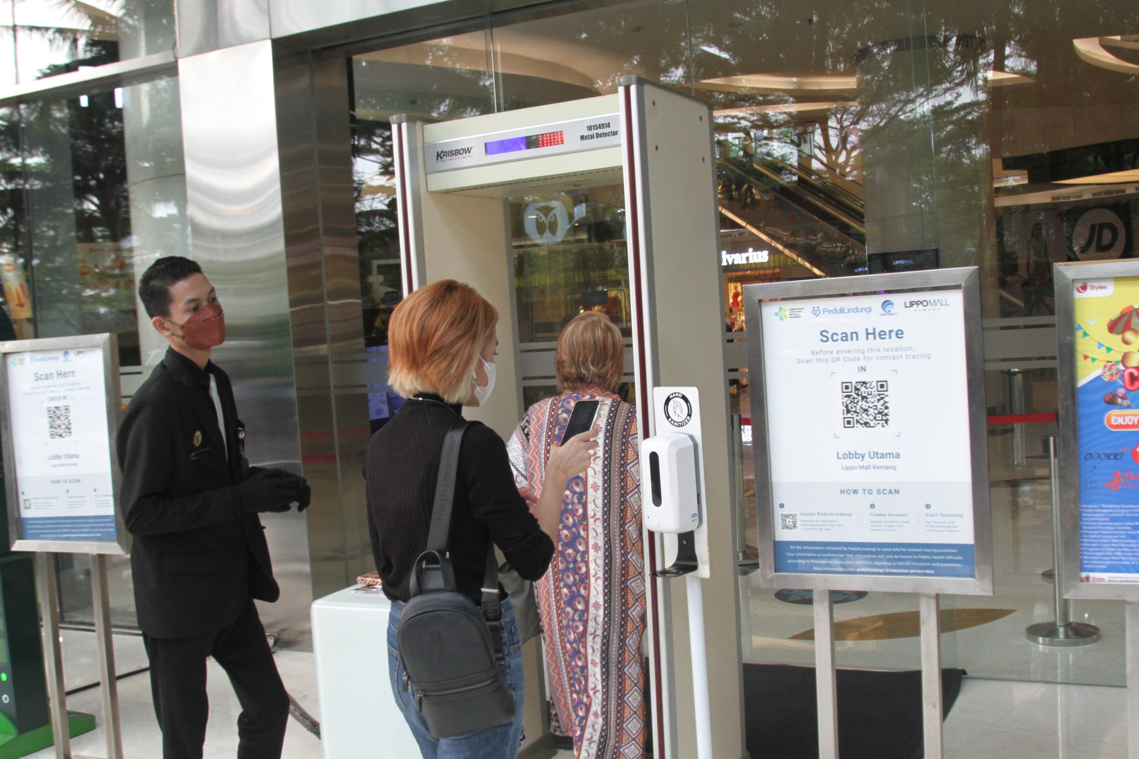 Pengunjung mall me-scan aplikasi pedulilindungi.id syarat masuk mall(Ashar/SinPo.id)