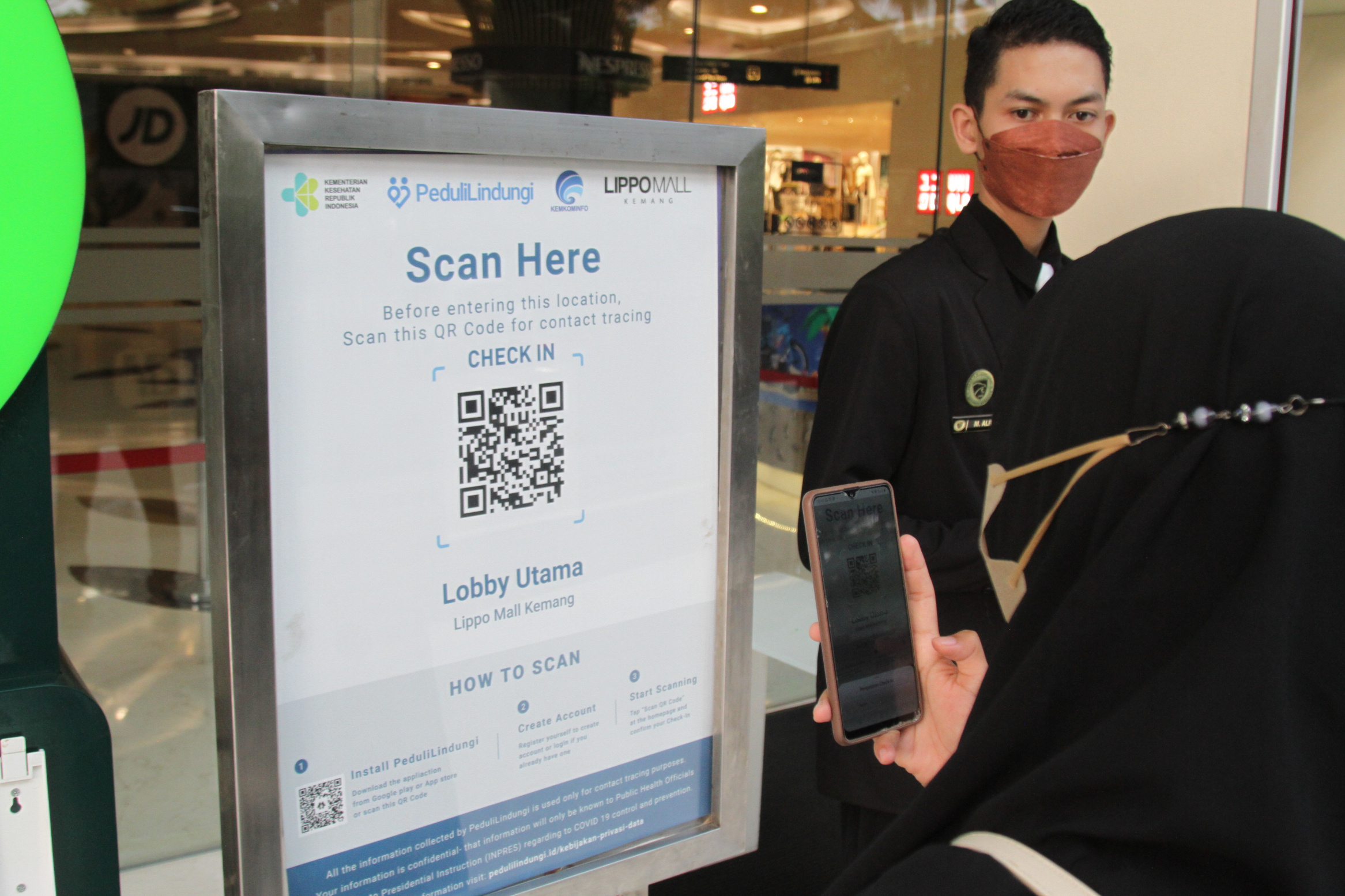 Pengunjung mall me-scan aplikasi pedulilindungi.id syarat masuk mall(Ashar/SinPo.id)