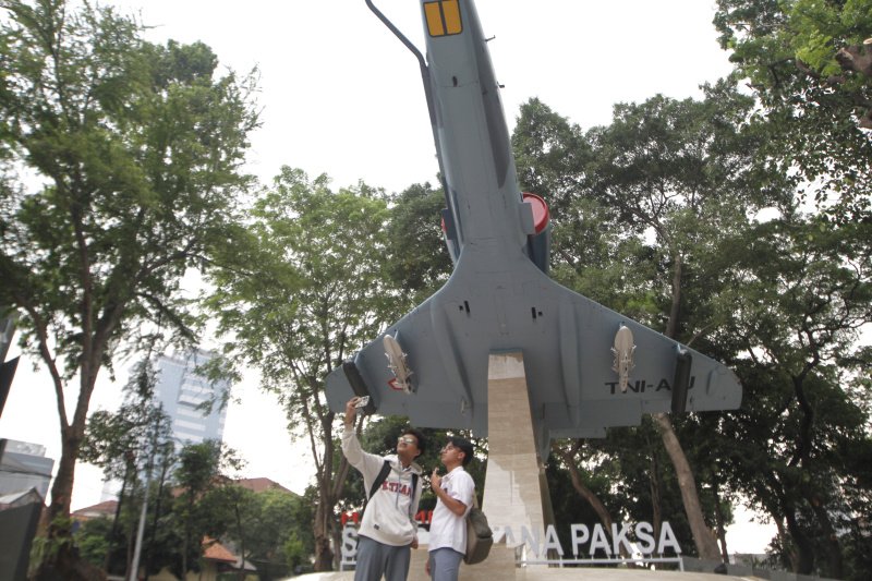 Warga berselfie ria di depan Monumen SWA BHUWANA PAKSA dengan berlatar belakang pesawat tempur A-4 Skyhawk milik TNI-AU (Ashar/SinPo.id)