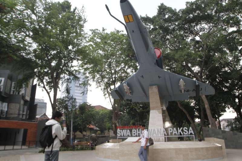 Warga berselfie ria di depan Monumen SWA BHUWANA PAKSA dengan berlatar belakang pesawat tempur A-4 Skyhawk milik TNI-AU (Ashar/SinPo.id)