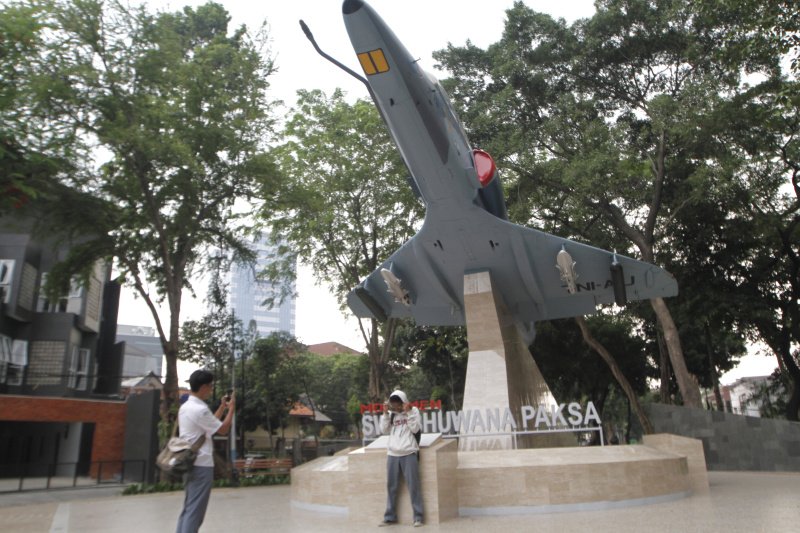 Warga berselfie ria di depan Monumen SWA BHUWANA PAKSA dengan berlatar belakang pesawat tempur A-4 Skyhawk milik TNI-AU (Ashar/SinPo.id)