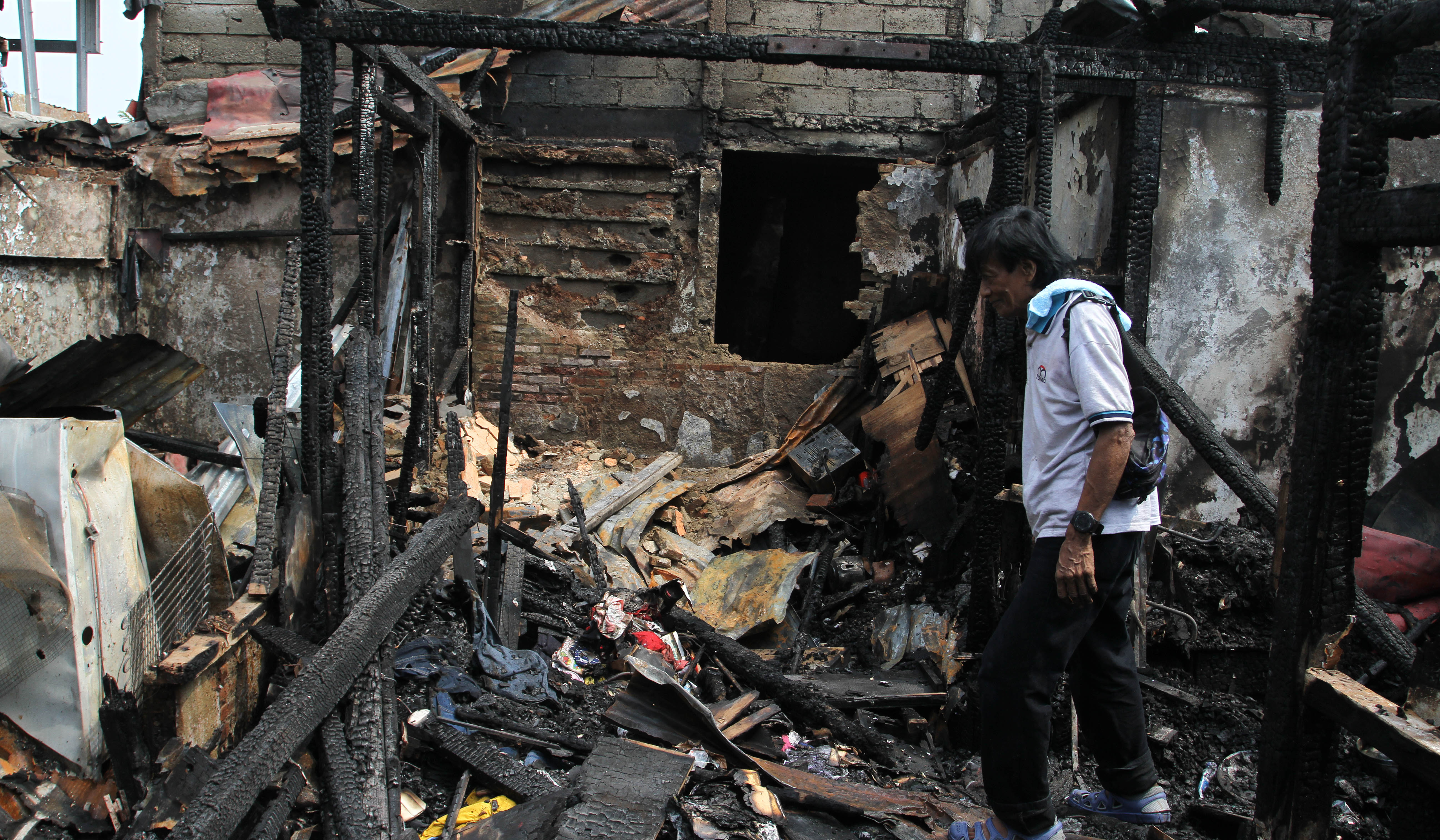 Warga mencari baju layak pakai dilokasi kebakaran. (Agus Priatna/SinPo.id)