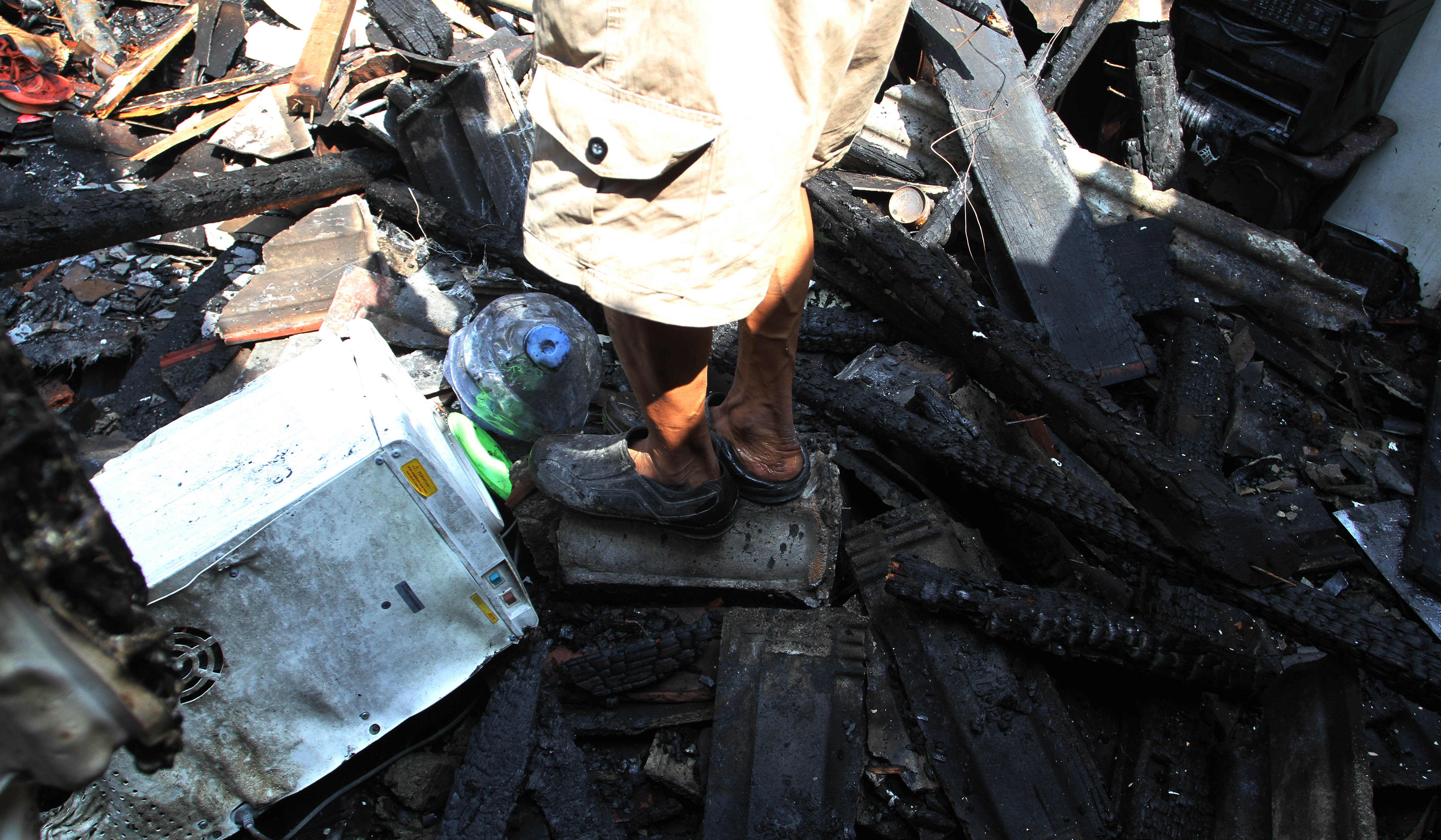 Warga mencari baju layak pakai dilokasi kebakaran. (Agus Priatna/SinPo.id)