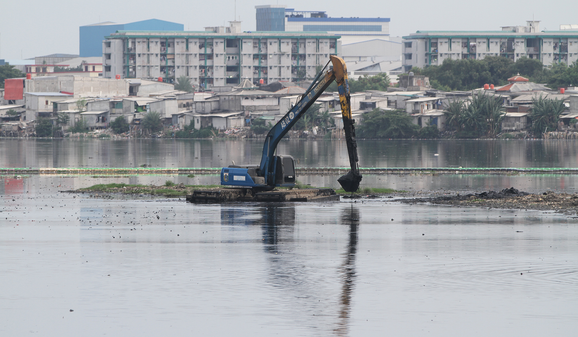 Pengerukan lumpur Waduk Pluit. (Agus Priatna/SinPo.id)