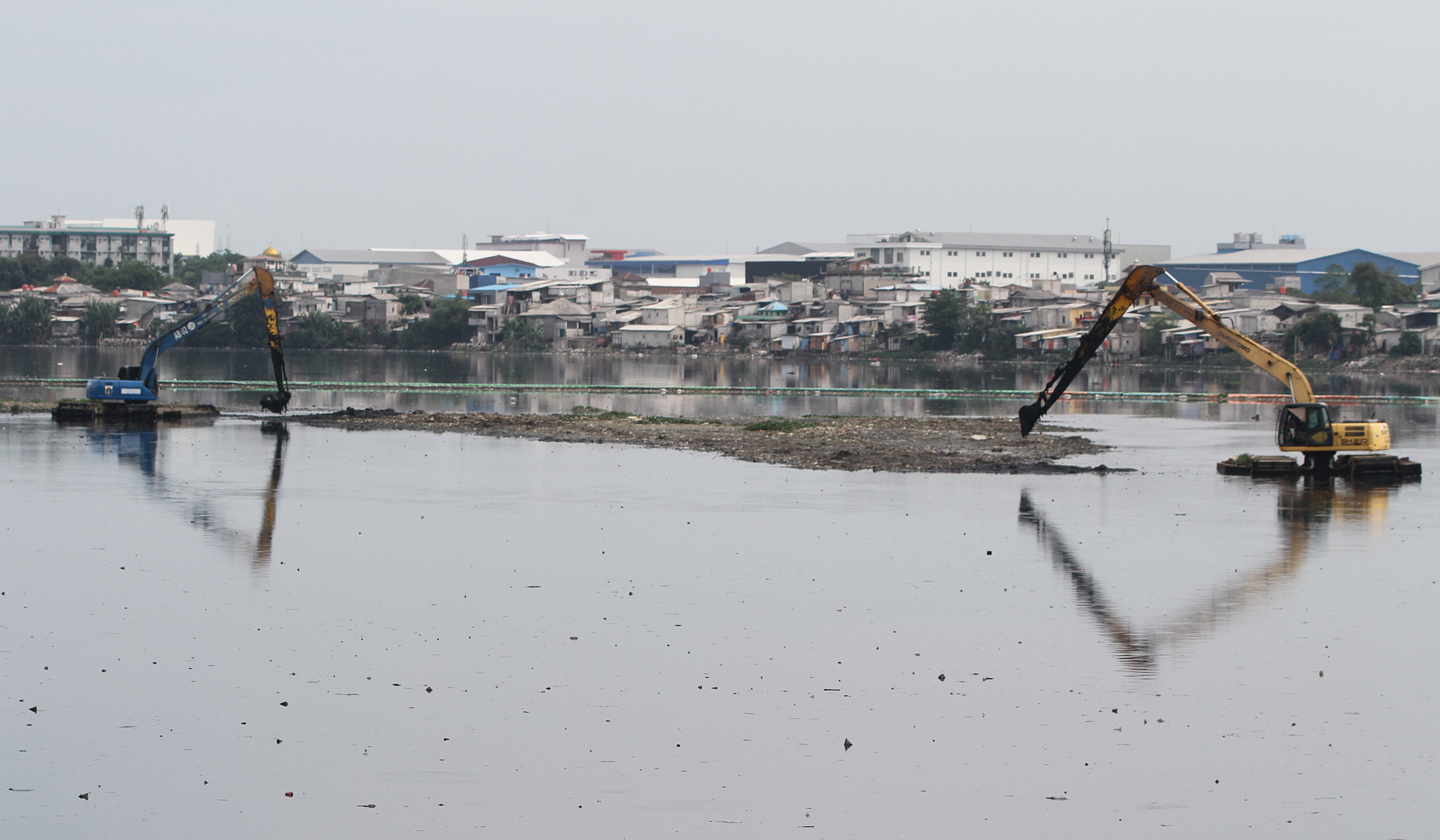 Pengerukan lumpur Waduk Pluit. (Agus Priatna/SinPo.id)