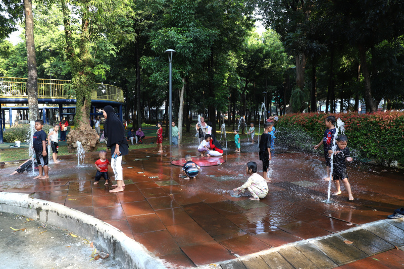 Warga Jakarta sedang menikmati liburan akhir pekan di RPTRA Taman Puring dengan Keluarga dan Anaknya bermain mandi Air Mancur (Ashar/SinPo.id)