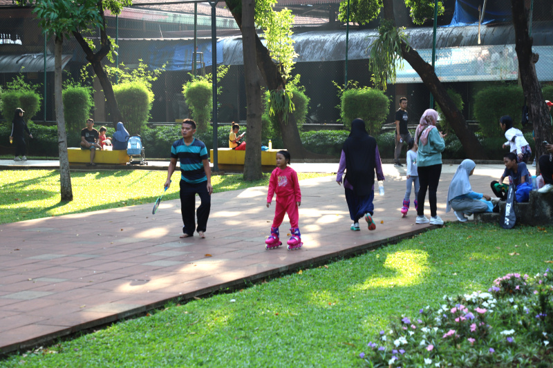 Warga Jakarta sedang menikmati liburan akhir pekan di RPTRA Taman Puring dengan Keluarga dan Anaknya bermain mandi Air Mancur (Ashar/SinPo.id)