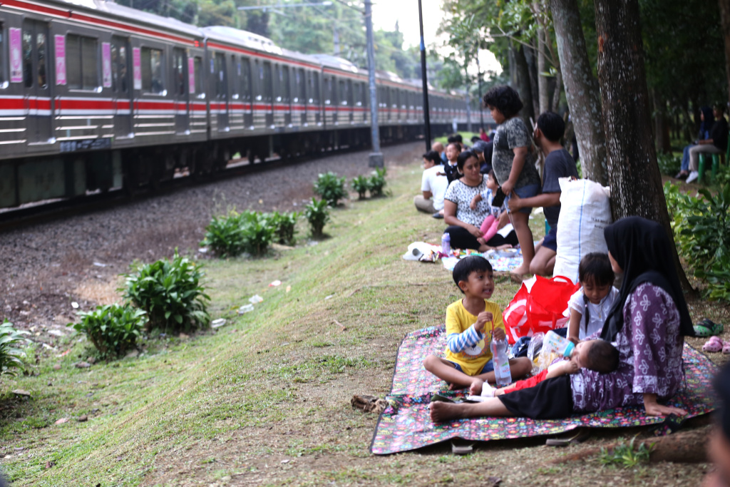 Warga sedang menunggu senja disamping rel kereta tanah kusir (Ashar/SinPo.id)