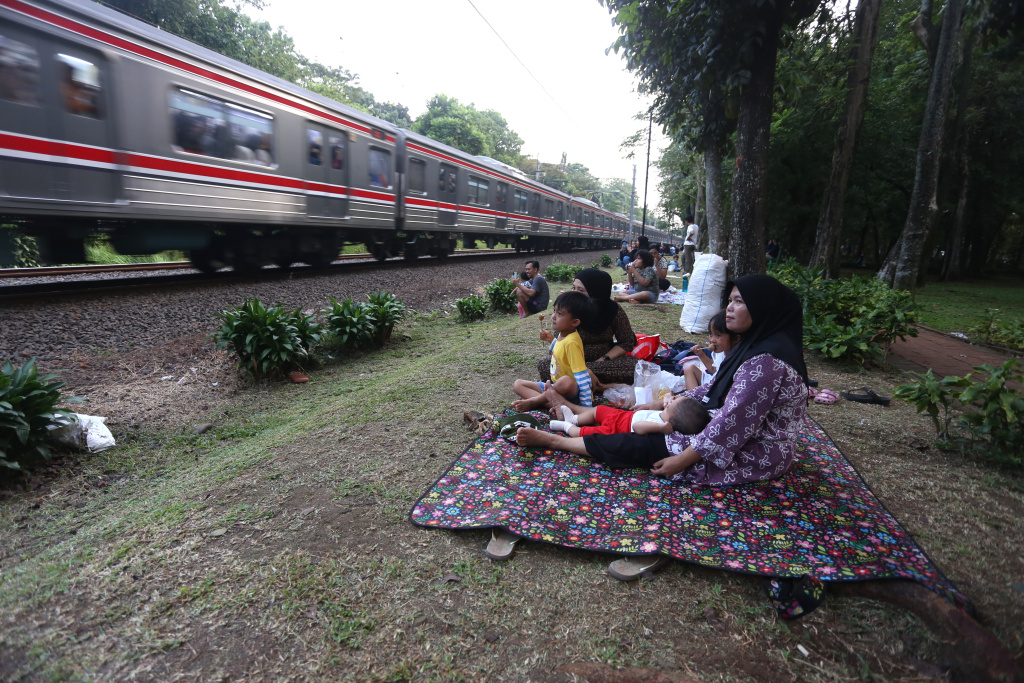 Warga sedang menunggu senja disamping rel kereta tanah kusir (Ashar/SinPo.id)
