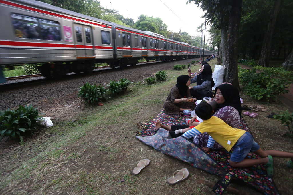 Warga sedang menunggu senja disamping rel kereta tanah kusir (Ashar/SinPo.id)