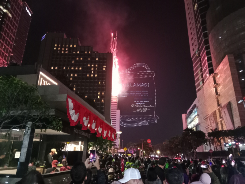 Warga sedang antusias melihat mobil hias karnaval kemerdekaan di bunderan HI (Ashar/SinPo.id)