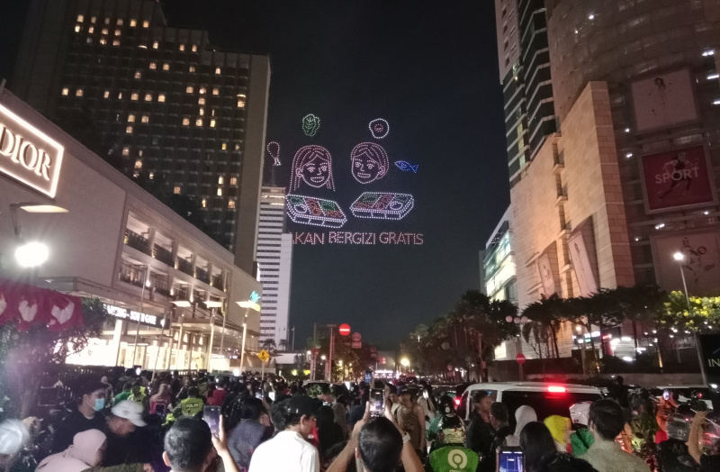 Warga sedang antusias melihat mobil hias karnaval kemerdekaan di bunderan HI (Ashar/SinPo.id)