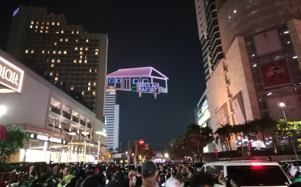 Warga sedang antusias melihat mobil hias karnaval kemerdekaan di bunderan HI (Ashar/SinPo.id)