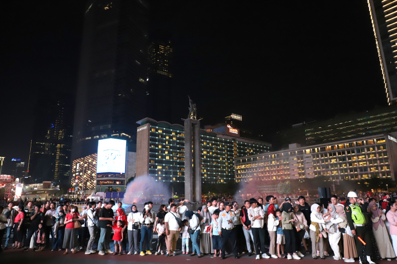 Warga sedang antusias melihat mobil hias karnaval kemerdekaan di bunderan HI (Ashar/SinPo.id)