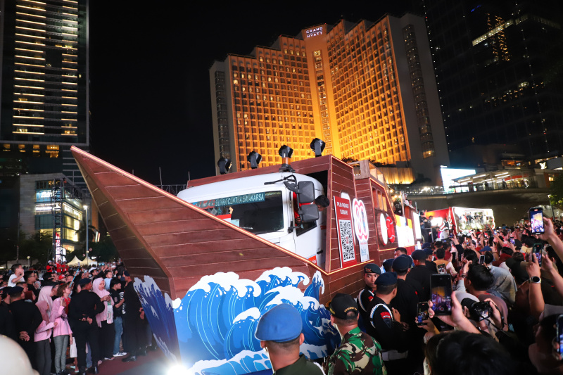 Warga sedang antusias melihat mobil hias karnaval kemerdekaan di bunderan HI (Ashar/SinPo.id)