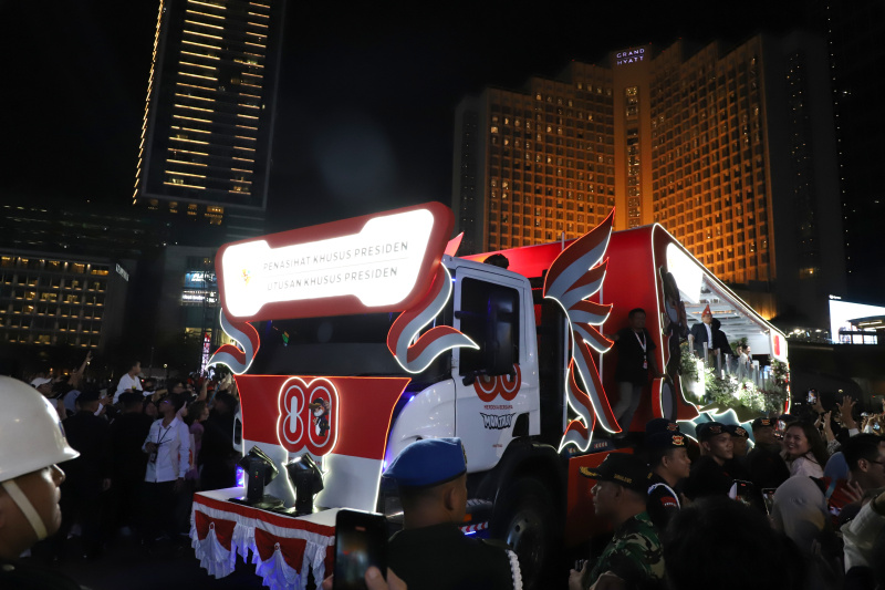 Warga sedang antusias melihat mobil hias karnaval kemerdekaan di bunderan HI (Ashar/SinPo.id)