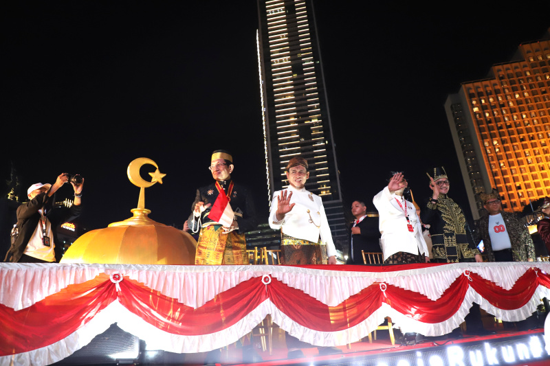 Warga sedang antusias melihat mobil hias karnaval kemerdekaan di bunderan HI (Ashar/SinPo.id)