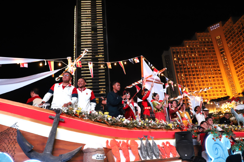 Warga sedang antusias melihat mobil hias karnaval kemerdekaan di bunderan HI (Ashar/SinPo.id)