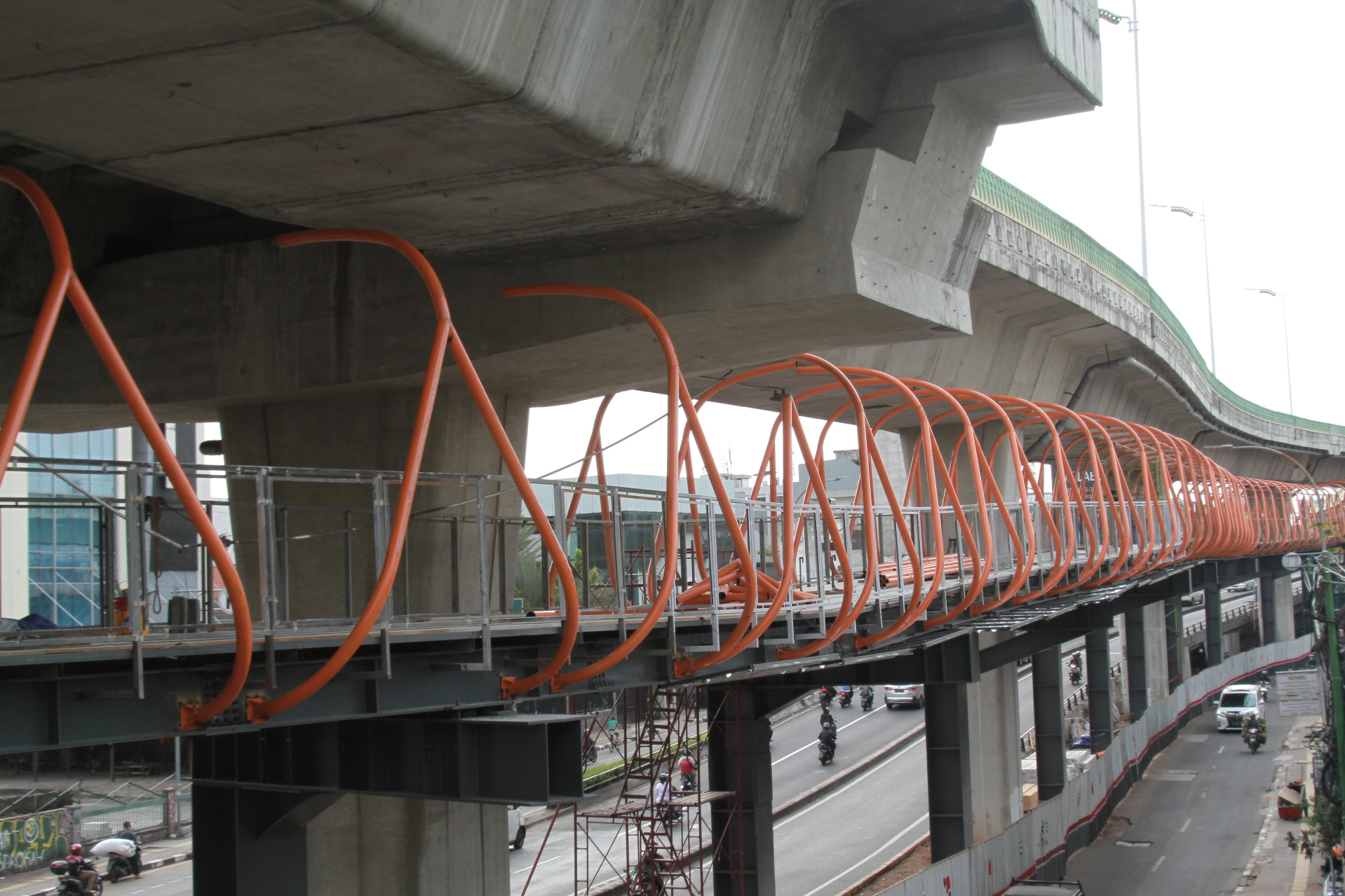 Para pekerja menyelesaikan pembangunan JPO Skywalk yang menghubungkan Halte Kebayoran dan Stasiun Kebayoran Lama (Ashar/SinPo.id)