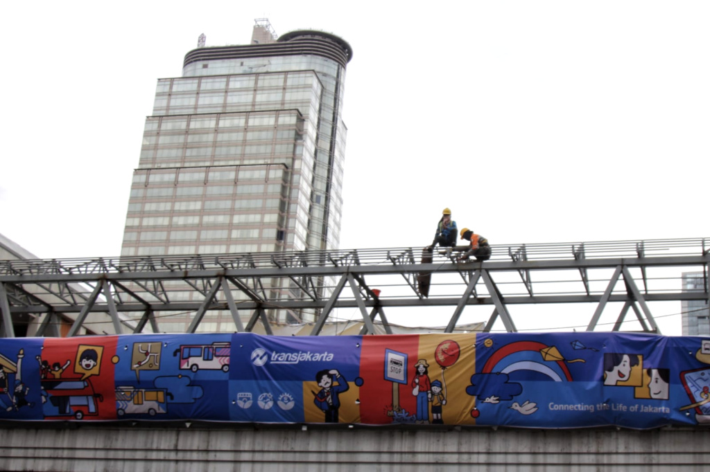 Pekerja sedang membangun kembali Jembatan Penyeberangan Orang Sarinah (Ashar/SinPo.id)