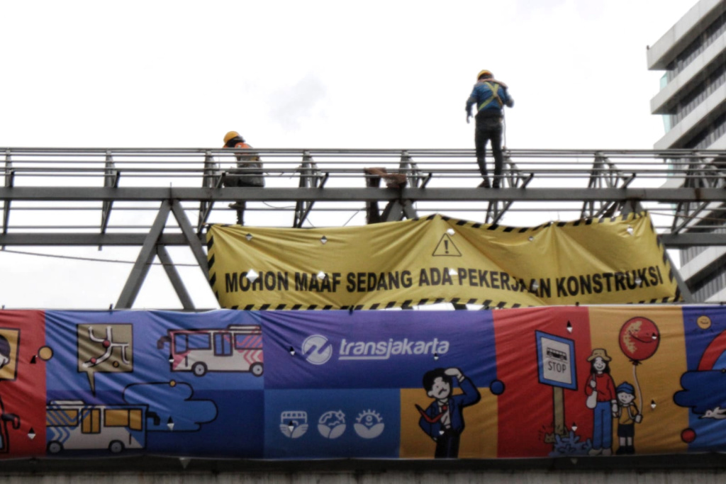 Pekerja sedang membangun kembali Jembatan Penyeberangan Orang Sarinah (Ashar/SinPo.id)