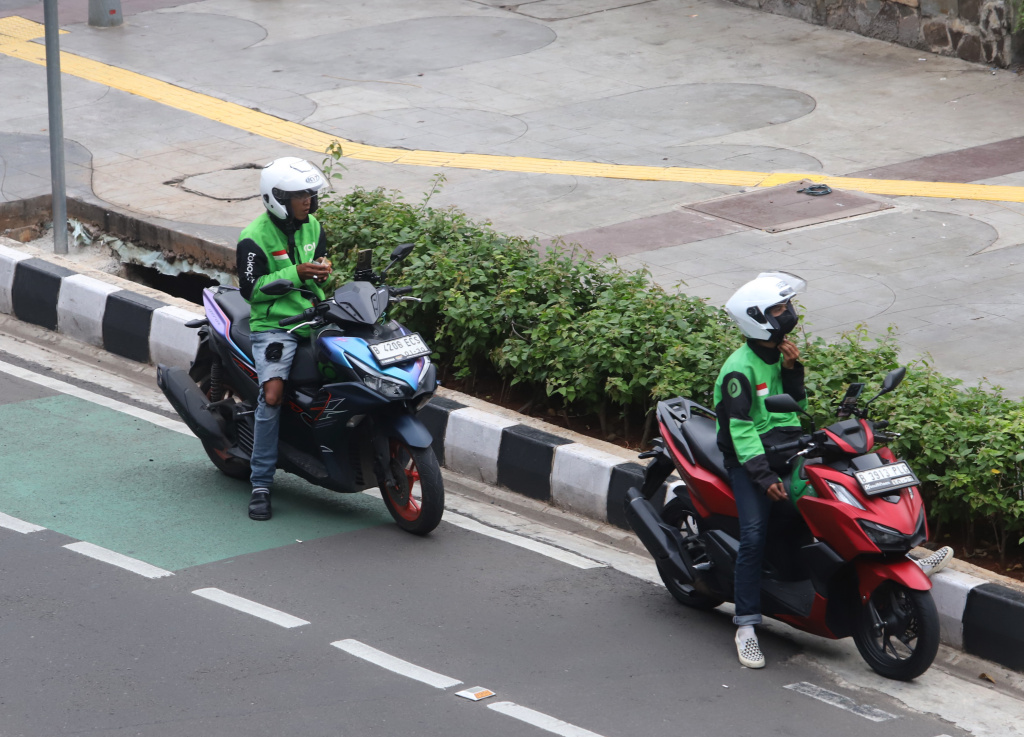 Pemerintah memberikan paket stimulus ekonomi 8+4+5 jaminan sosial untuk ojek online mendapatkan jaminan JKK,JKM dan JHT (Ashar/SinPo.id)
