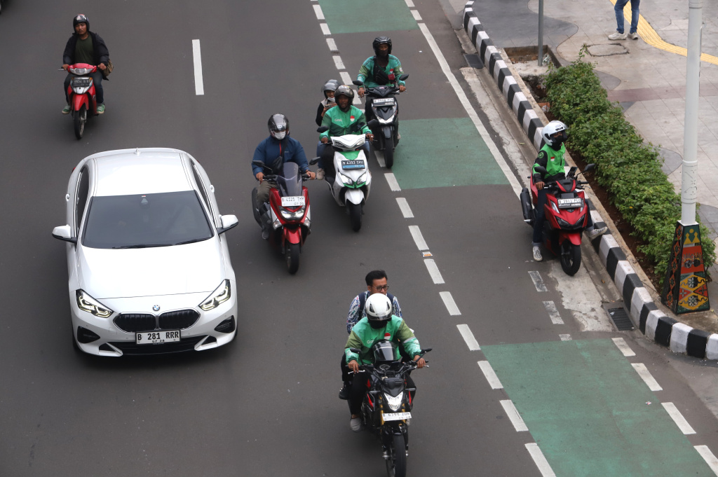 Pemerintah memberikan paket stimulus ekonomi 8+4+5 jaminan sosial untuk ojek online mendapatkan jaminan JKK,JKM dan JHT (Ashar/SinPo.id)