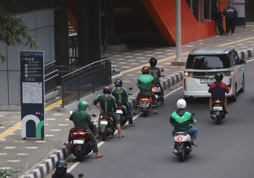 Pemerintah memberikan paket stimulus ekonomi 8+4+5 jaminan sosial untuk ojek online mendapatkan jaminan JKK,JKM dan JHT (Ashar/SinPo.id)