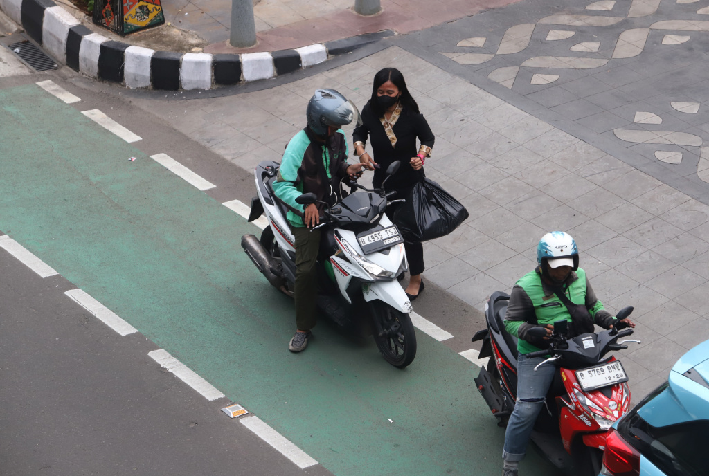 Pemerintah memberikan paket stimulus ekonomi 8+4+5 jaminan sosial untuk ojek online mendapatkan jaminan JKK,JKM dan JHT (Ashar/SinPo.id)