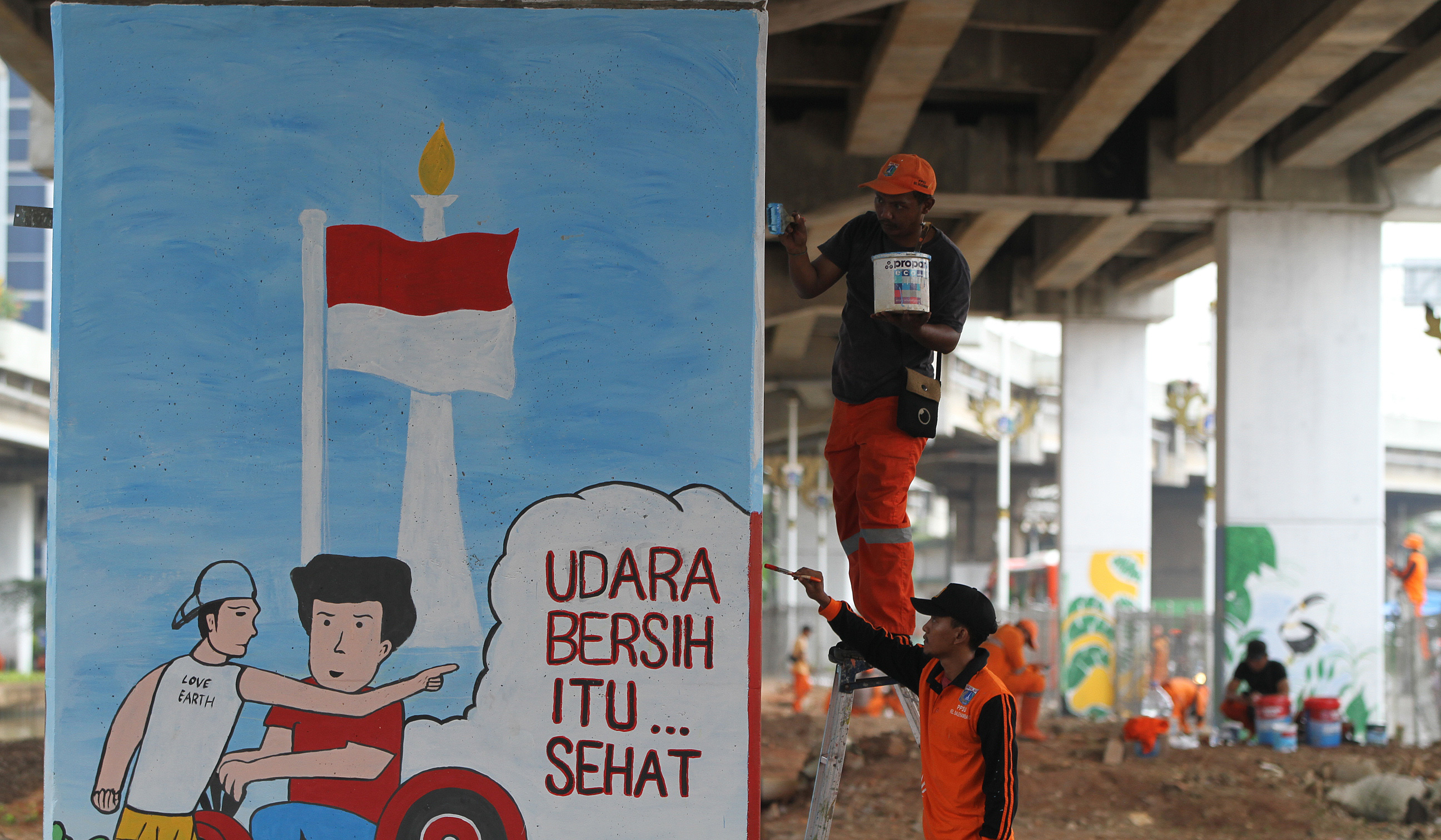 Pasukan oranye mengecat mural dikolong tol Becakayu. (Agus Priatna/SinPo.id)