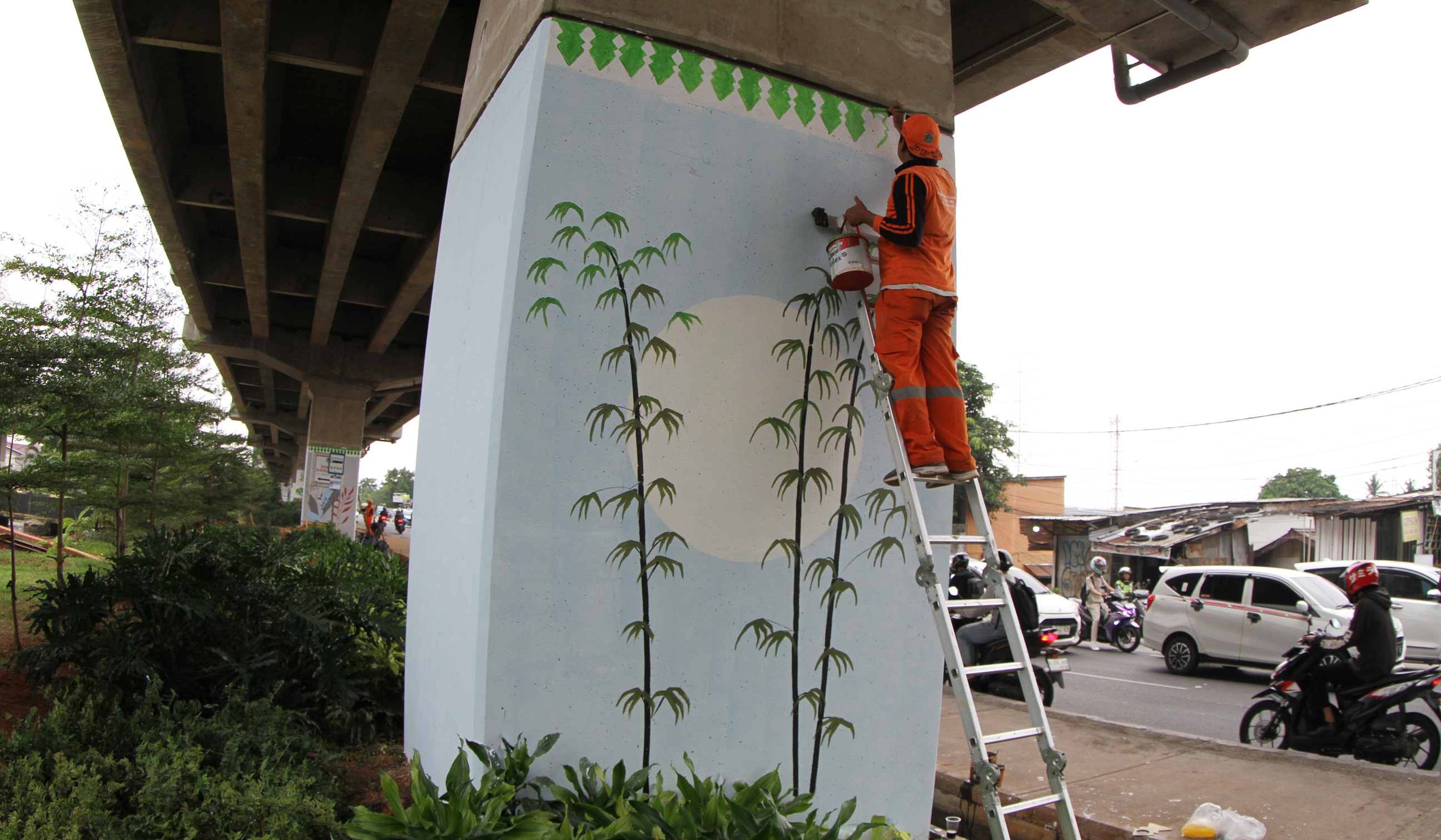 Pasukan oranye mengecat mural dikolong tol Becakayu. (Agus Priatna/SinPo.id)