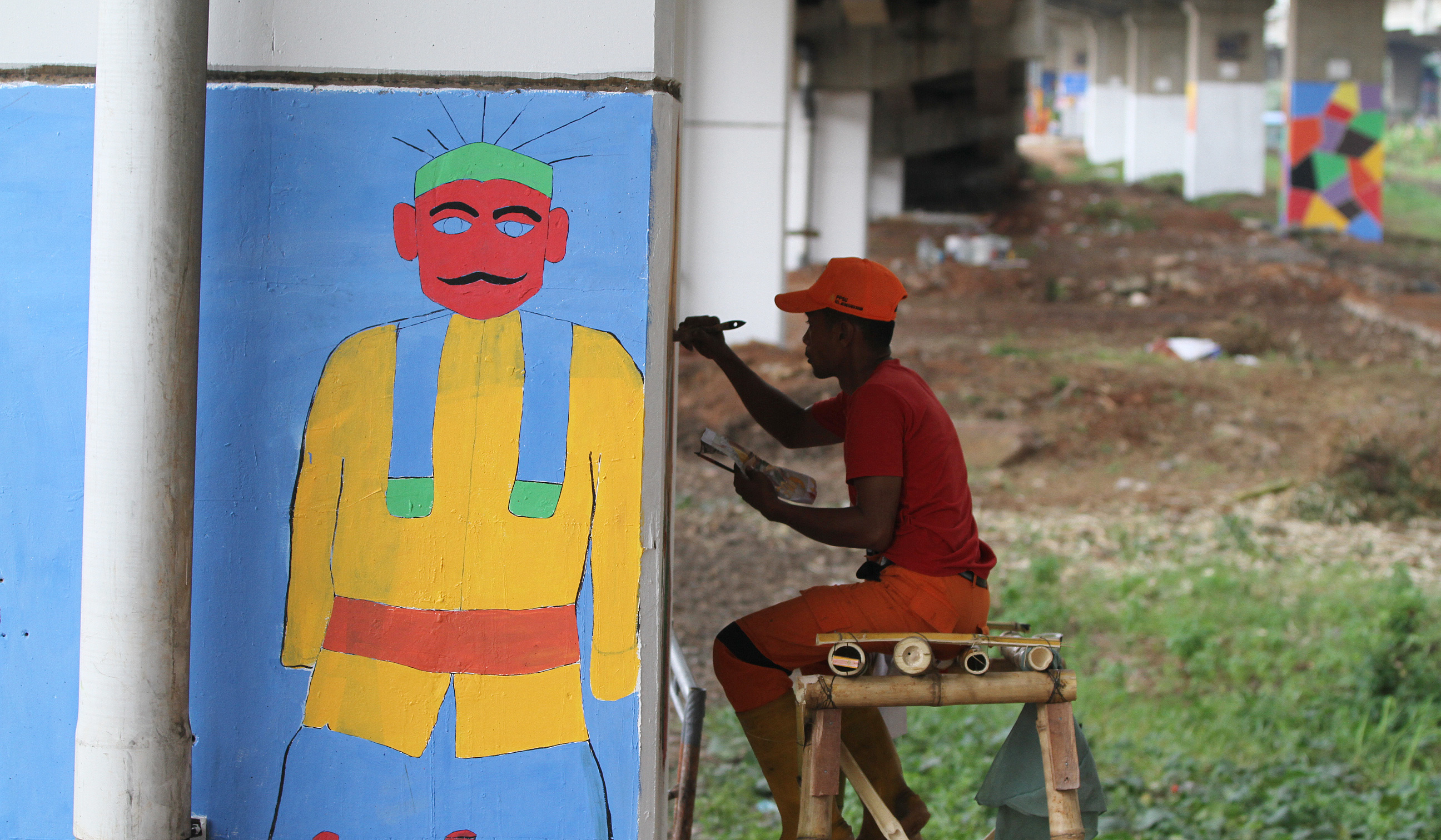 Pasukan oranye mengecat mural dikolong tol Becakayu. (Agus Priatna/SinPo.id)