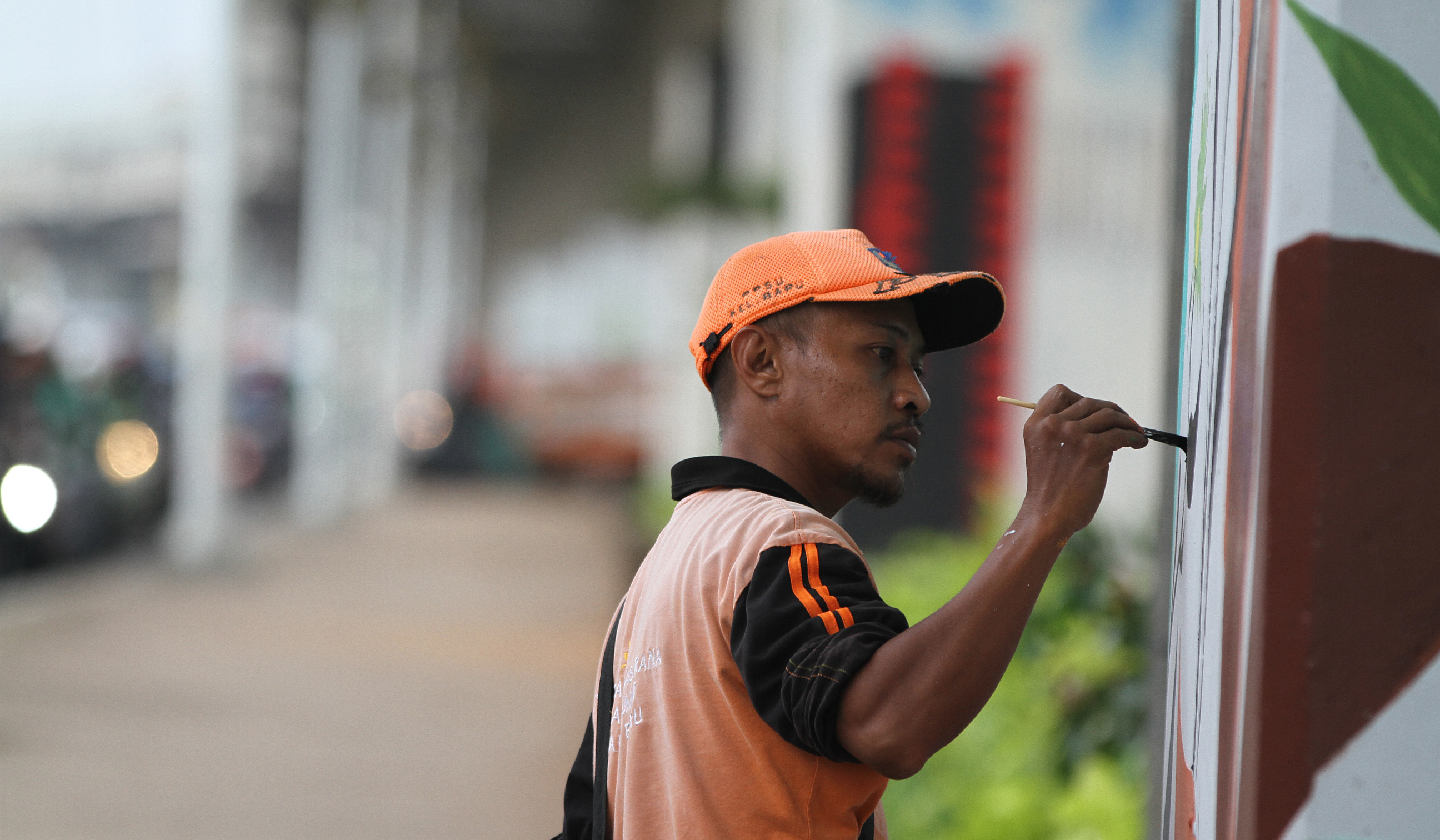 Pasukan oranye mengecat mural dikolong tol Becakayu. (Agus Priatna/SinPo.id)