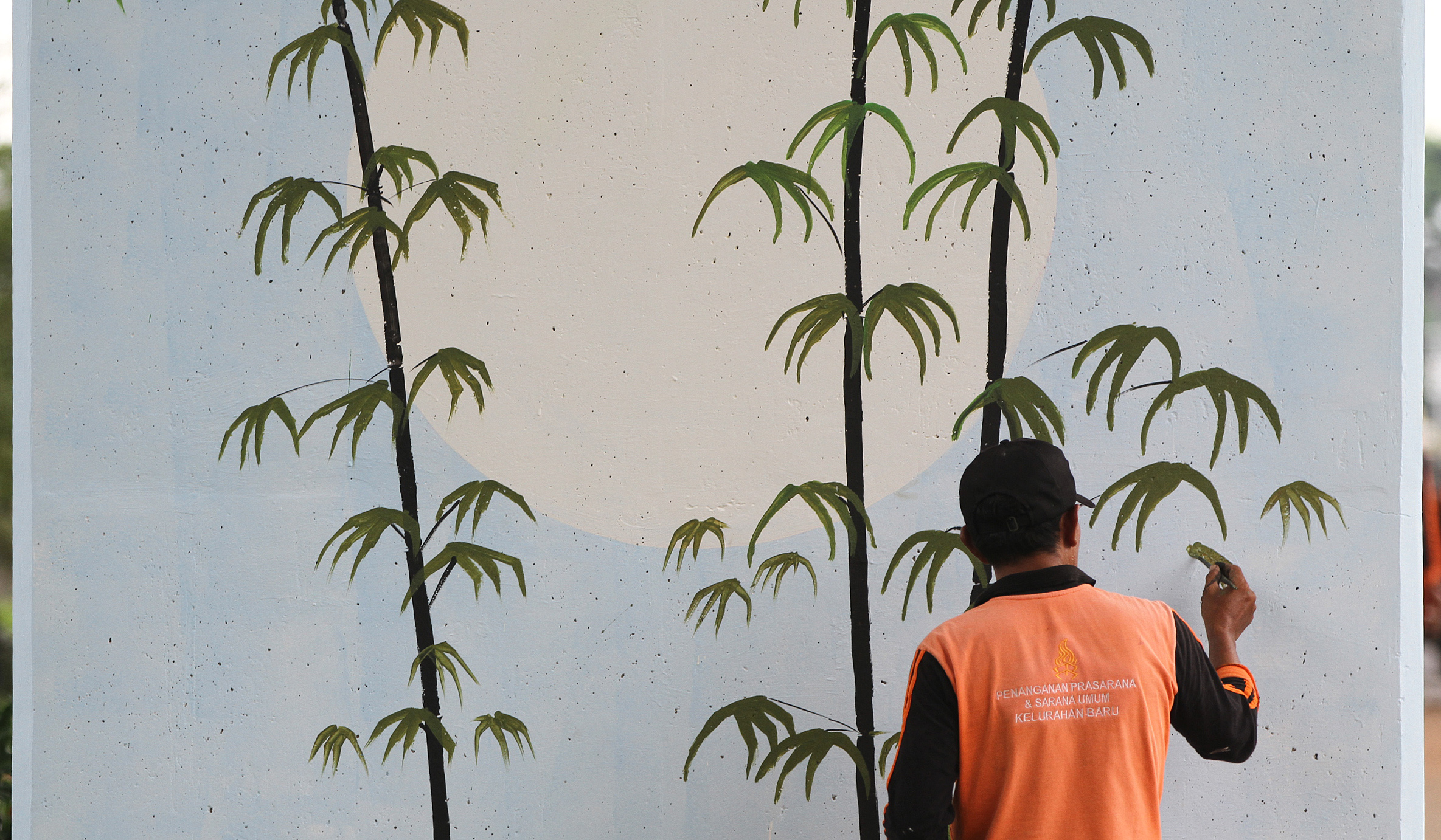 Pasukan oranye mengecat mural dikolong tol Becakayu. (Agus Priatna/SinPo.id)