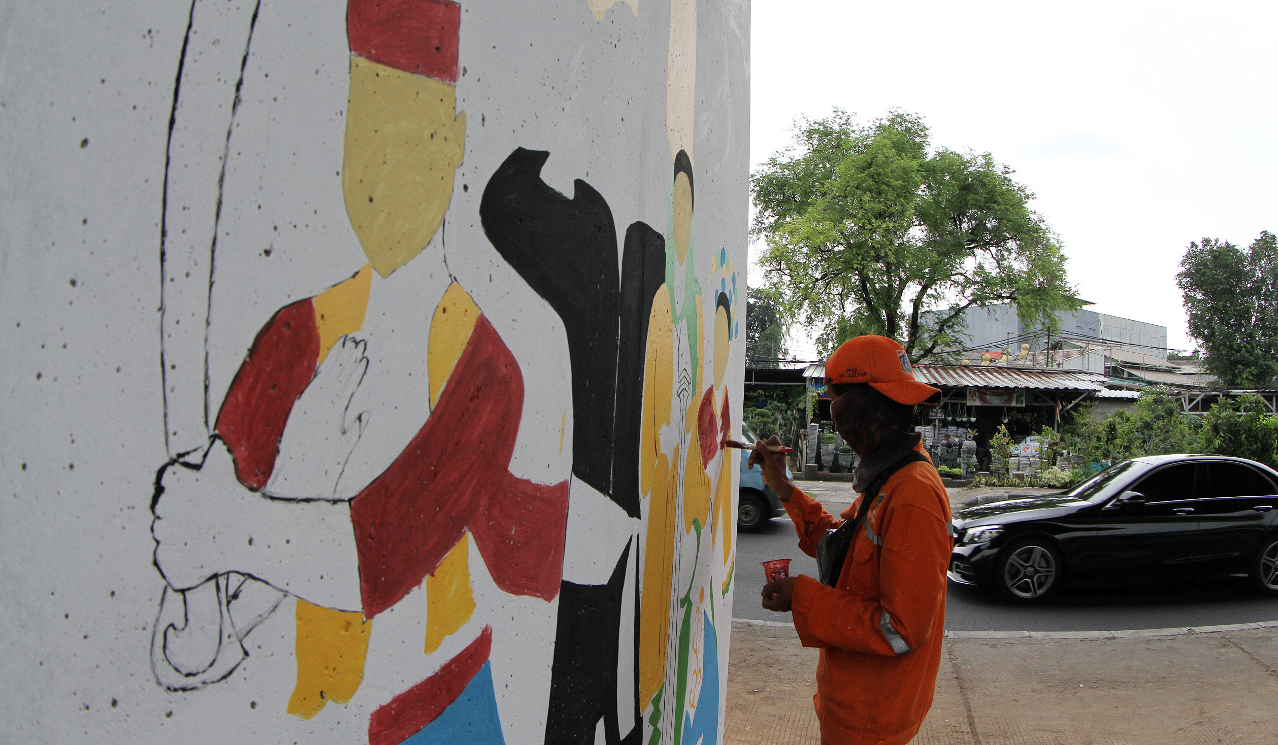 Pasukan oranye mengecat mural dikolong tol Becakayu. (Agus Priatna/SinPo.id)