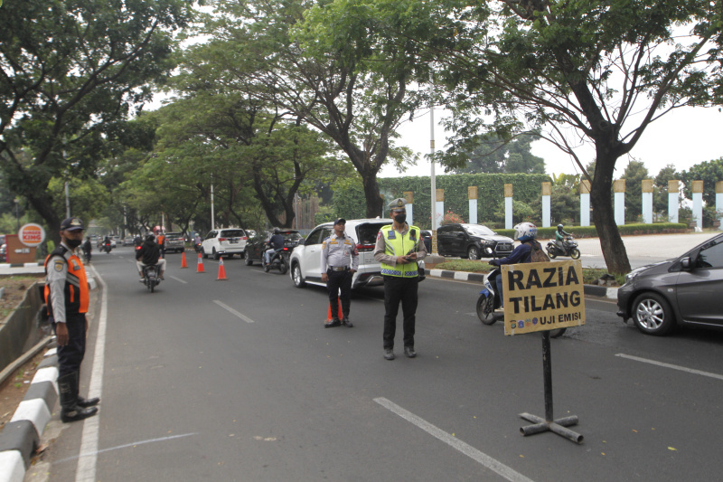 Petugaa gabungan Polda Metro Jaya dan Auku Dinas Lingkungan Hidup Jakarta Barat menggelar razia uji emisi kendaraan bermotor di lingkar luar Meruya (Ashar/SinPo.id)