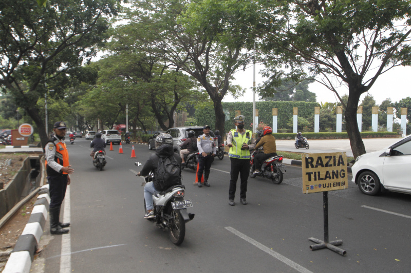 Petugaa gabungan Polda Metro Jaya dan Auku Dinas Lingkungan Hidup Jakarta Barat menggelar razia uji emisi kendaraan bermotor di lingkar luar Meruya (Ashar/SinPo.id)