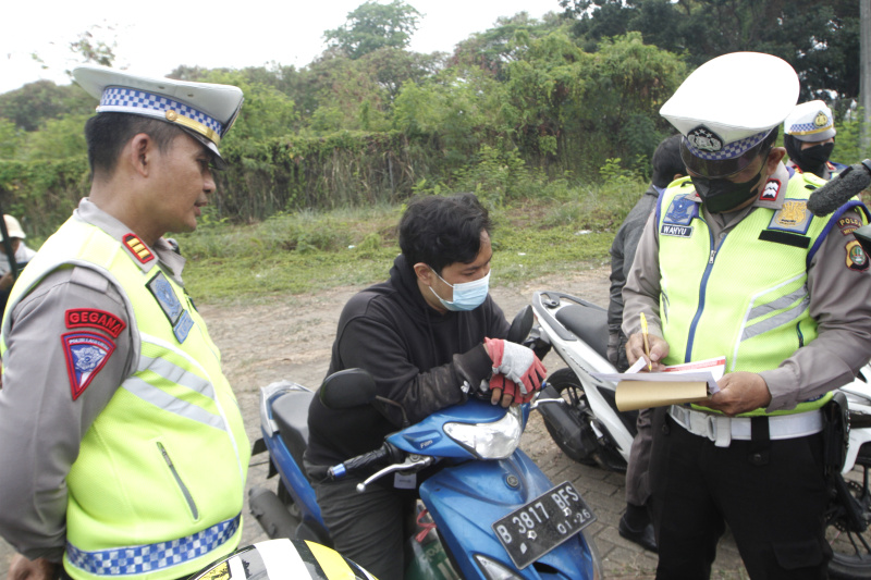 Petugaa gabungan Polda Metro Jaya dan Auku Dinas Lingkungan Hidup Jakarta Barat menggelar razia uji emisi kendaraan bermotor di lingkar luar Meruya (Ashar/SinPo.id)