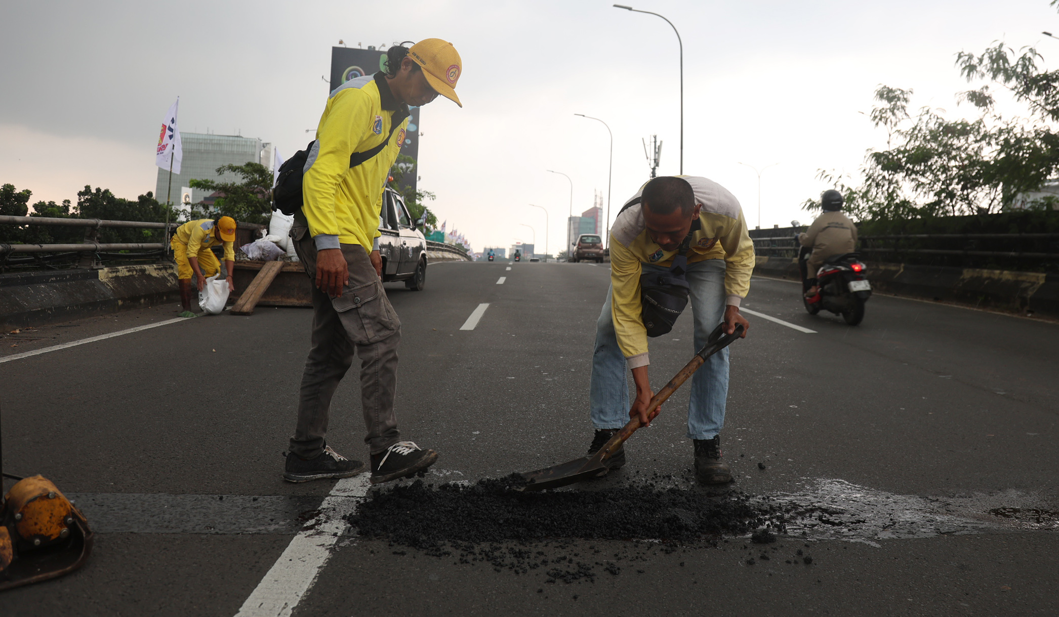 Perbaikan jalan berlubang. (Agus Priatna/SinPo.id)