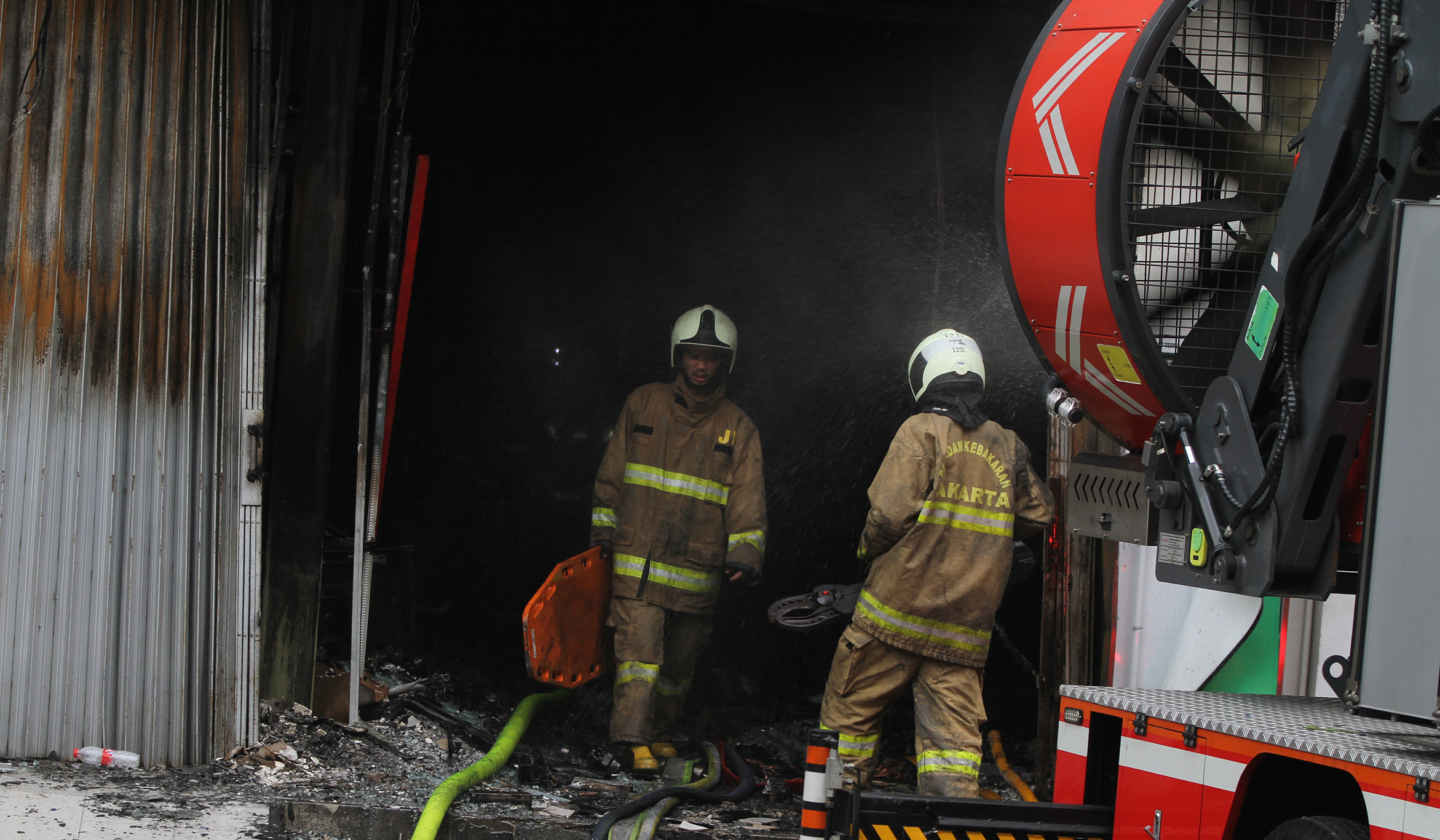 Petugas usai memadamkan api di gedung Terra Drone. (Agus Priatna/SinPo.id)