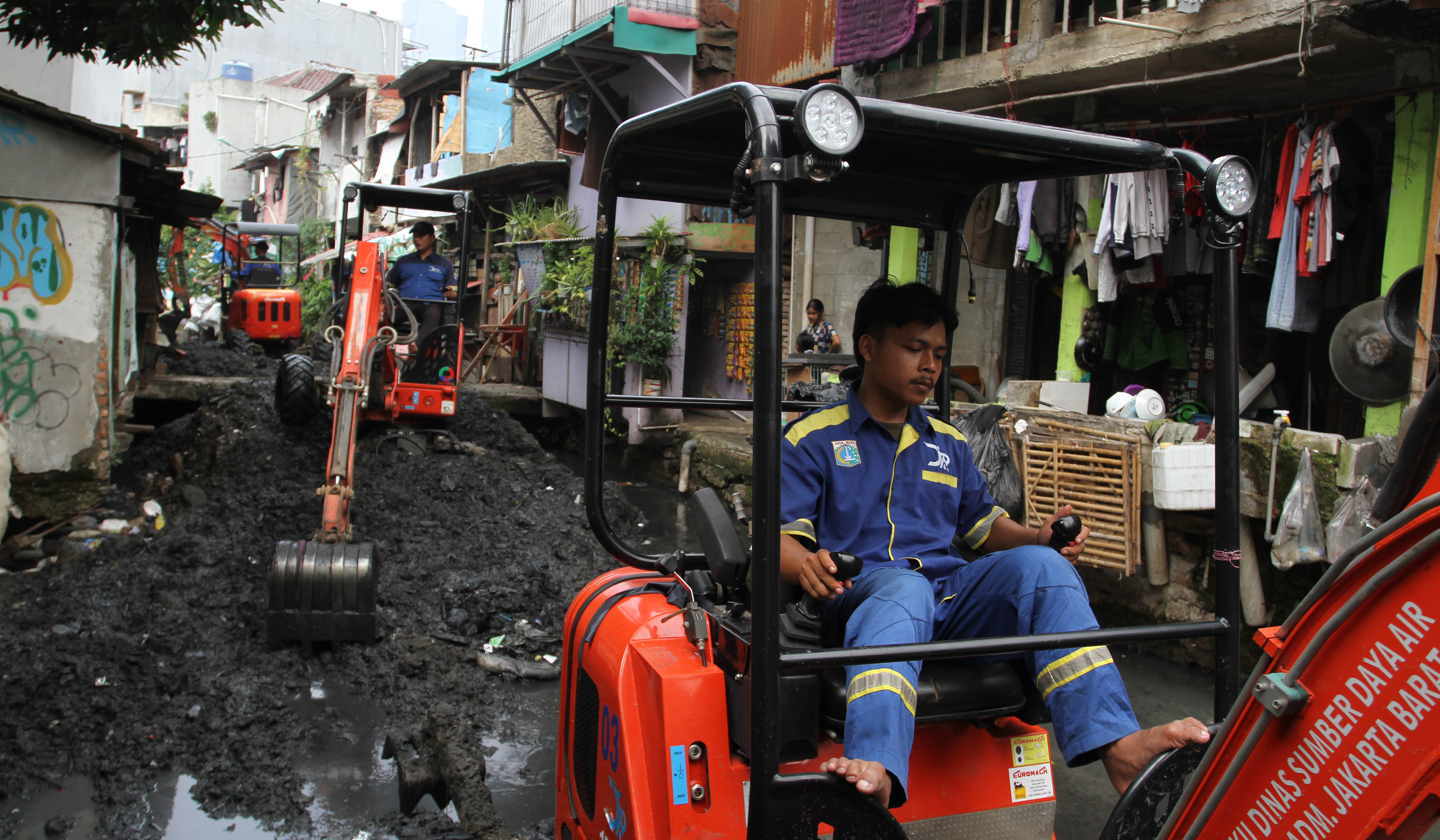 Petugas keruk lumpur kali Krukut. (Agus Priatna/SinPo.id)