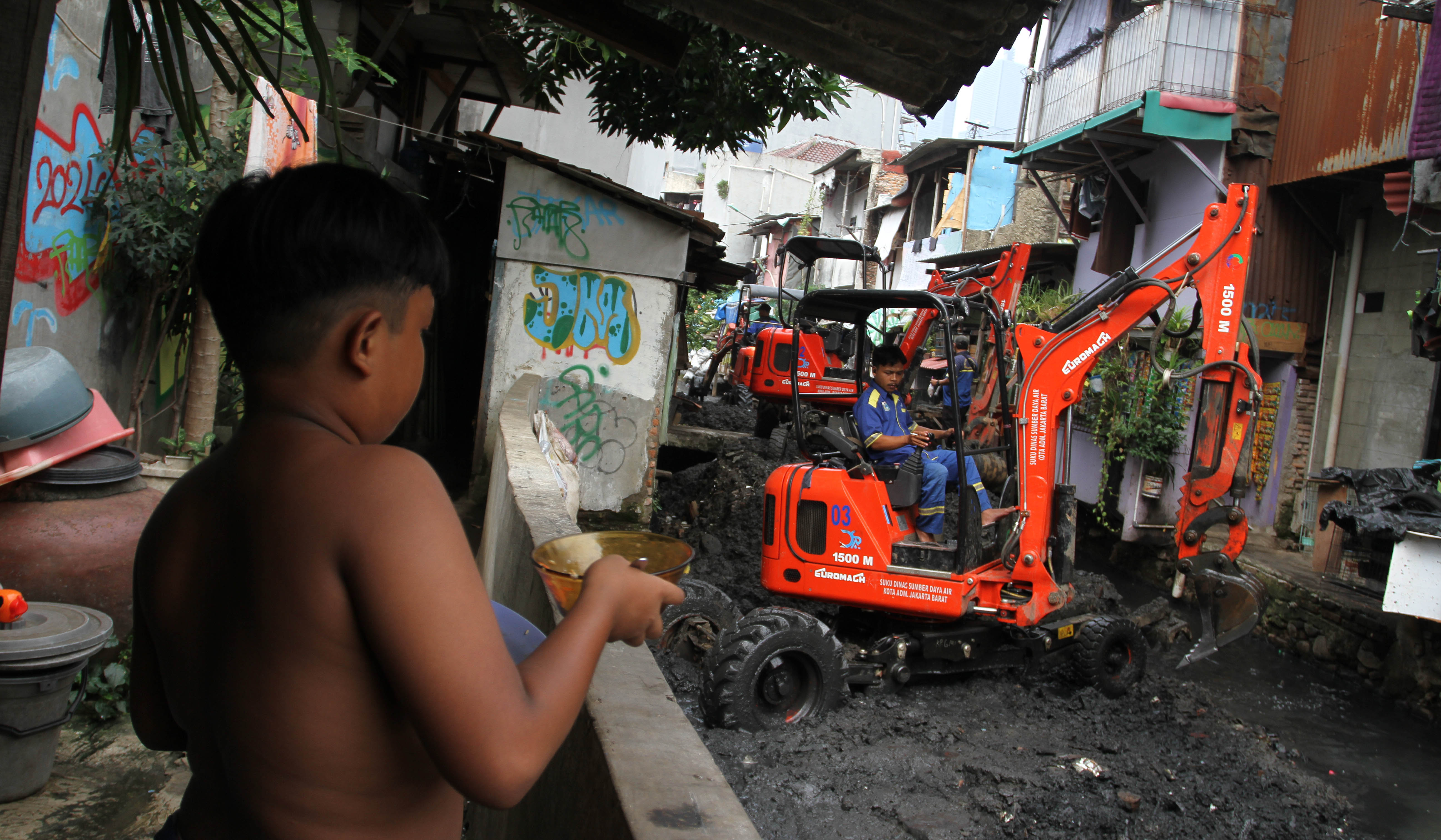 Petugas keruk lumpur kali Krukut. (Agus Priatna/SinPo.id)